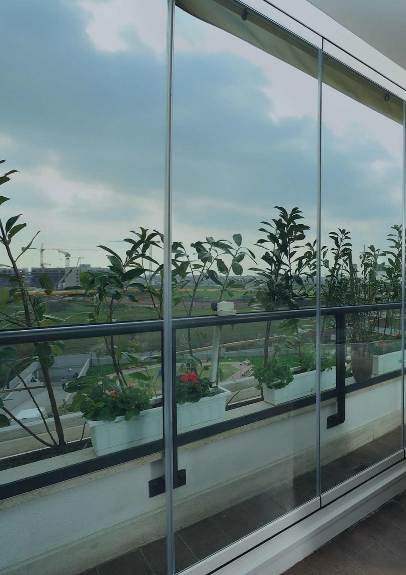 Sliding glass balcony enclosure with plants